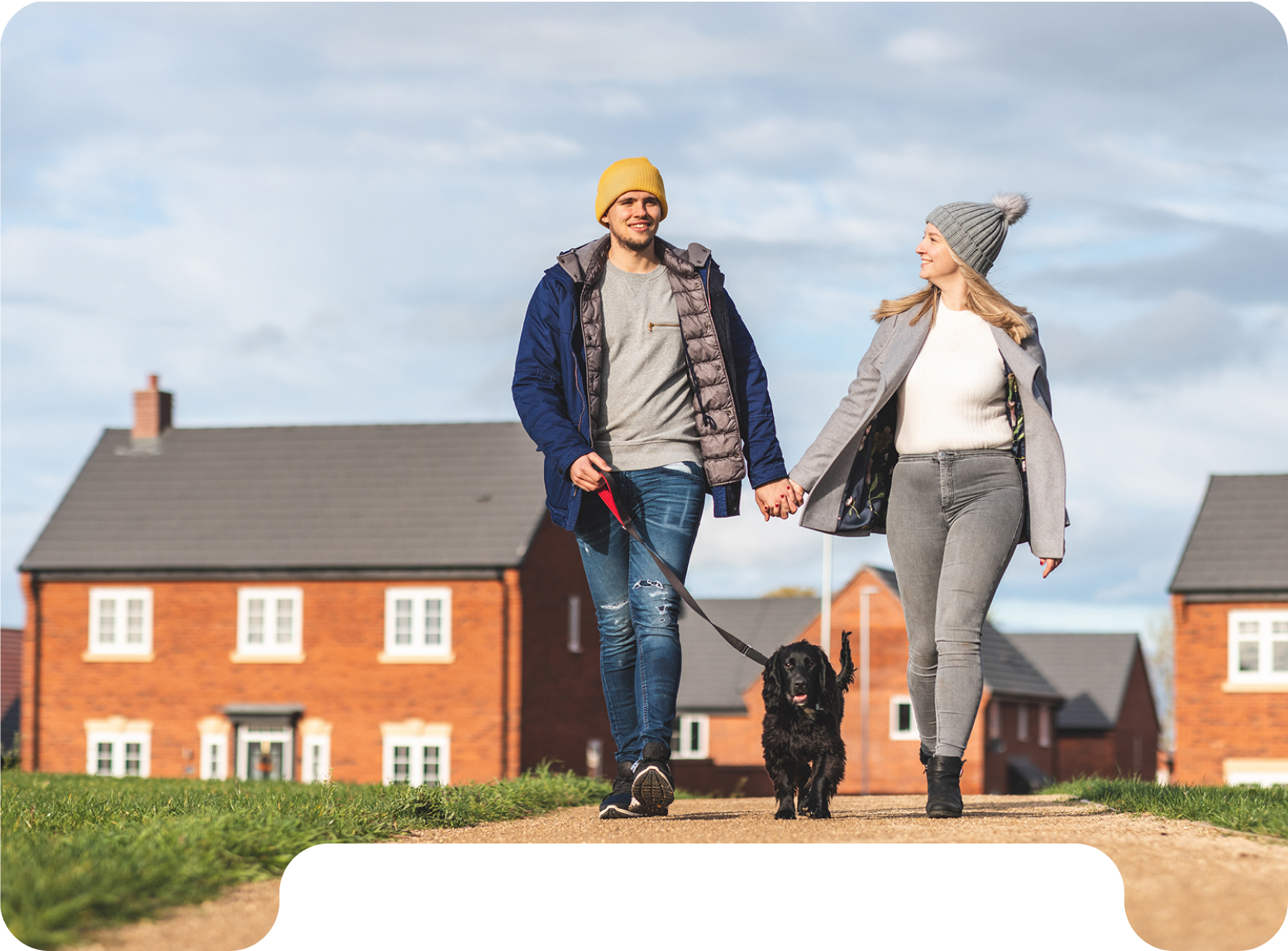 Couple walking a dog outside new homes