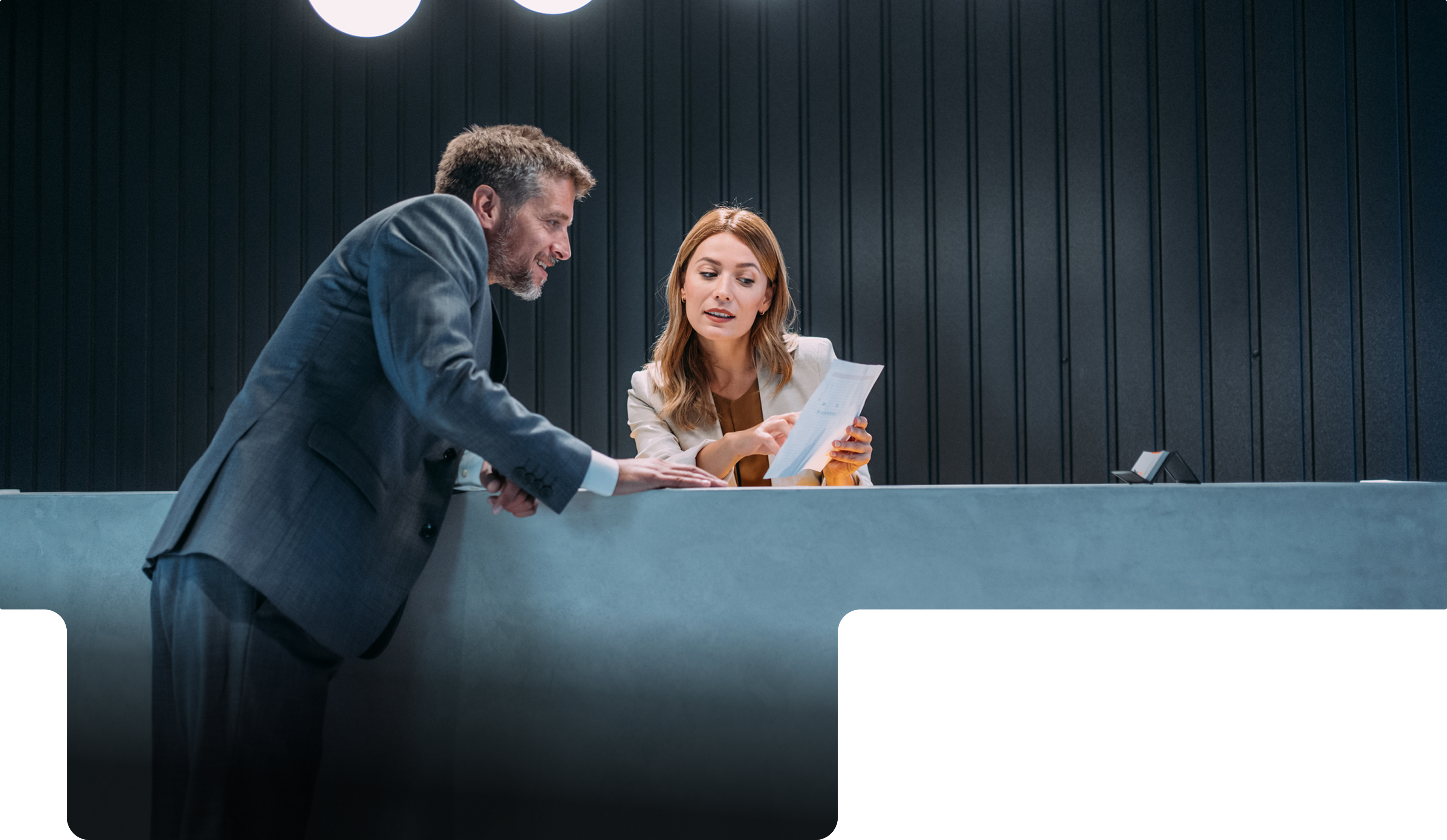 A leasing manager reviewing documents with a resident at reception