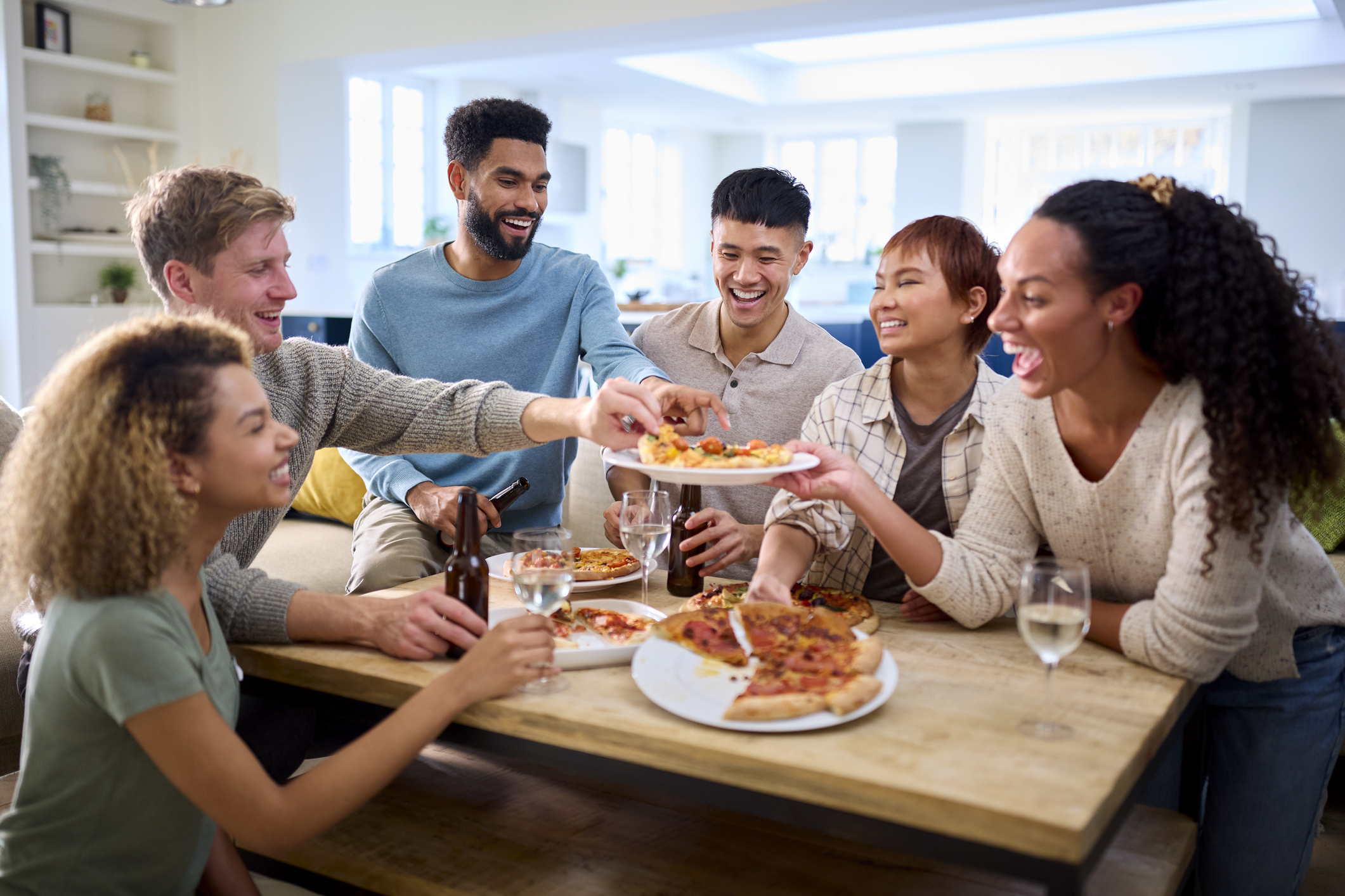 Friends sharing pizza around a dining table